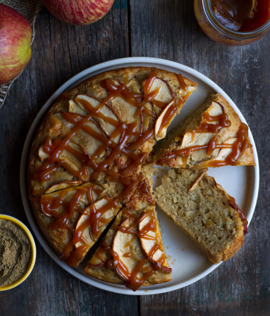 Sliced apple cake drizzled with caramel sauce.