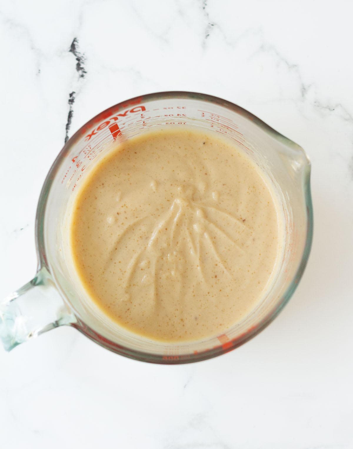 whisked wet ingredients in a glass measuring cup.