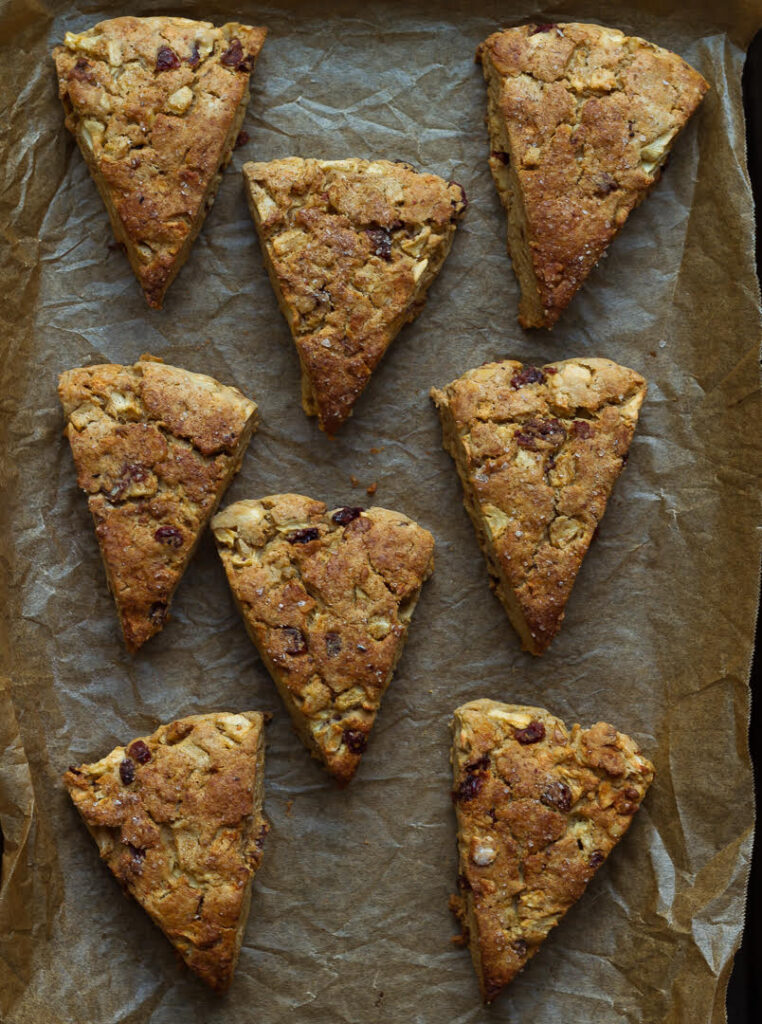Baked apple scones on a parchment lined tray.