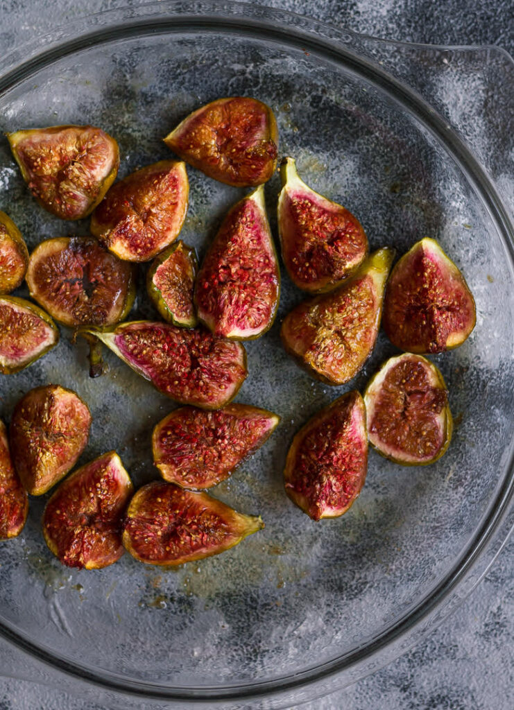 Roasted figs in a glass dish.