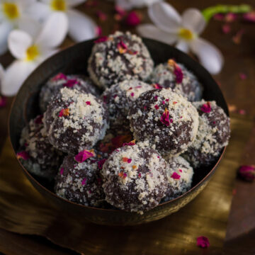 Chocolate Pedas in a serving bowl with flowers in the background.