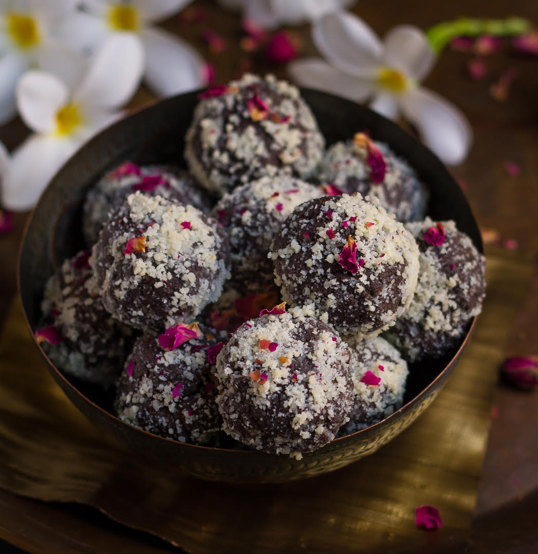 Chocolate Pedas in a serving bowl with flowers in the background.