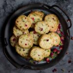 Rose pistachio cookies in a serving tray garnished with dried rose buds.