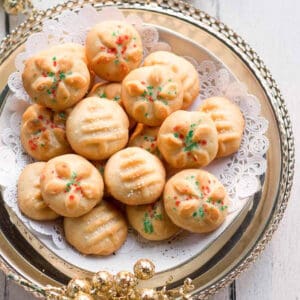 Cookies with white, red, and green sprinkles on a tray.