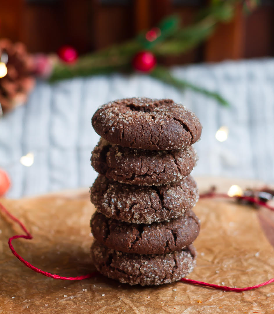 Five Chocolate ginger cookies stacked up on parchment paper with a red string.