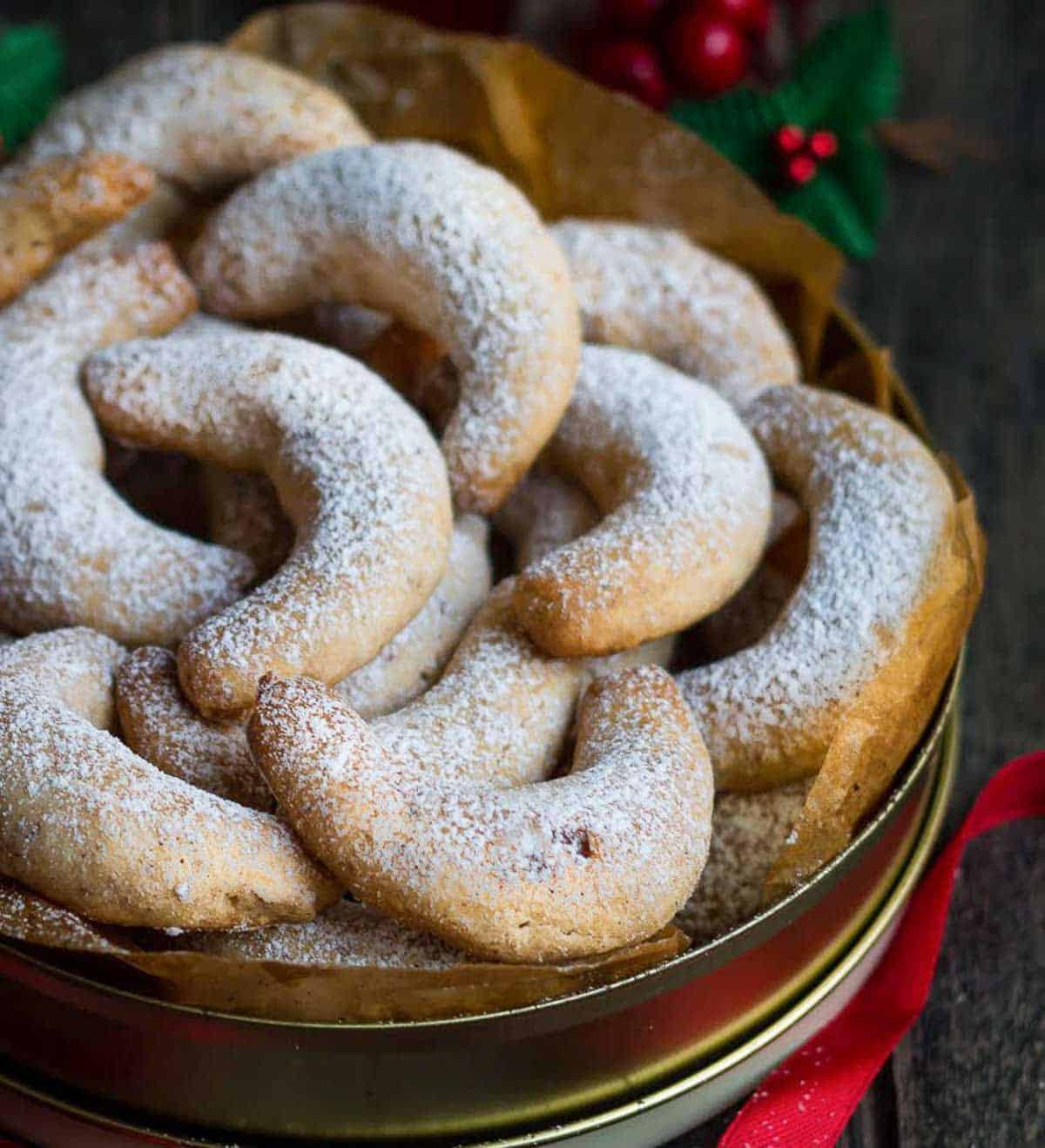 Sugar coated cookies in a paper-lined tin.