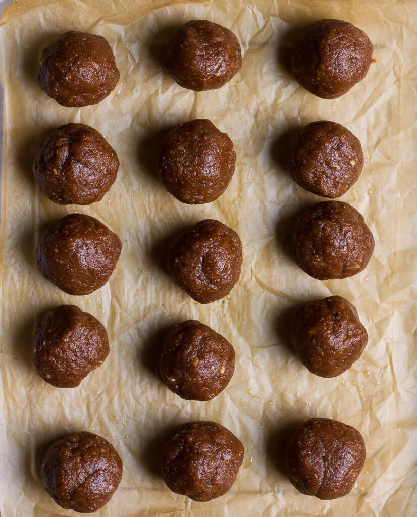 Cookie dough balls on parchment paper.