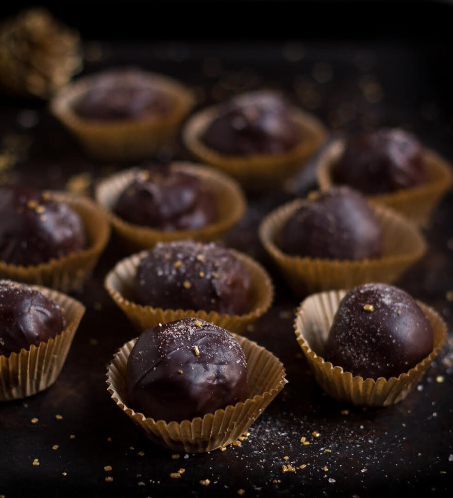 No bake gingersnap cookies in mini cupcake liners on a black tray.