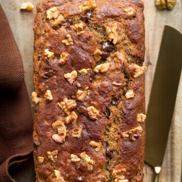 Miso banana bread on a wooden board with a knife.