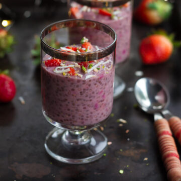 strawberry chia pudding in a dessert glass with a spoon.