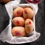 strawberry jam donuts in a loaf pan lined with parchment paper.