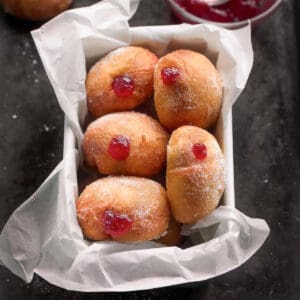 strawberry jam donuts in a loaf pan lined with parchment paper.