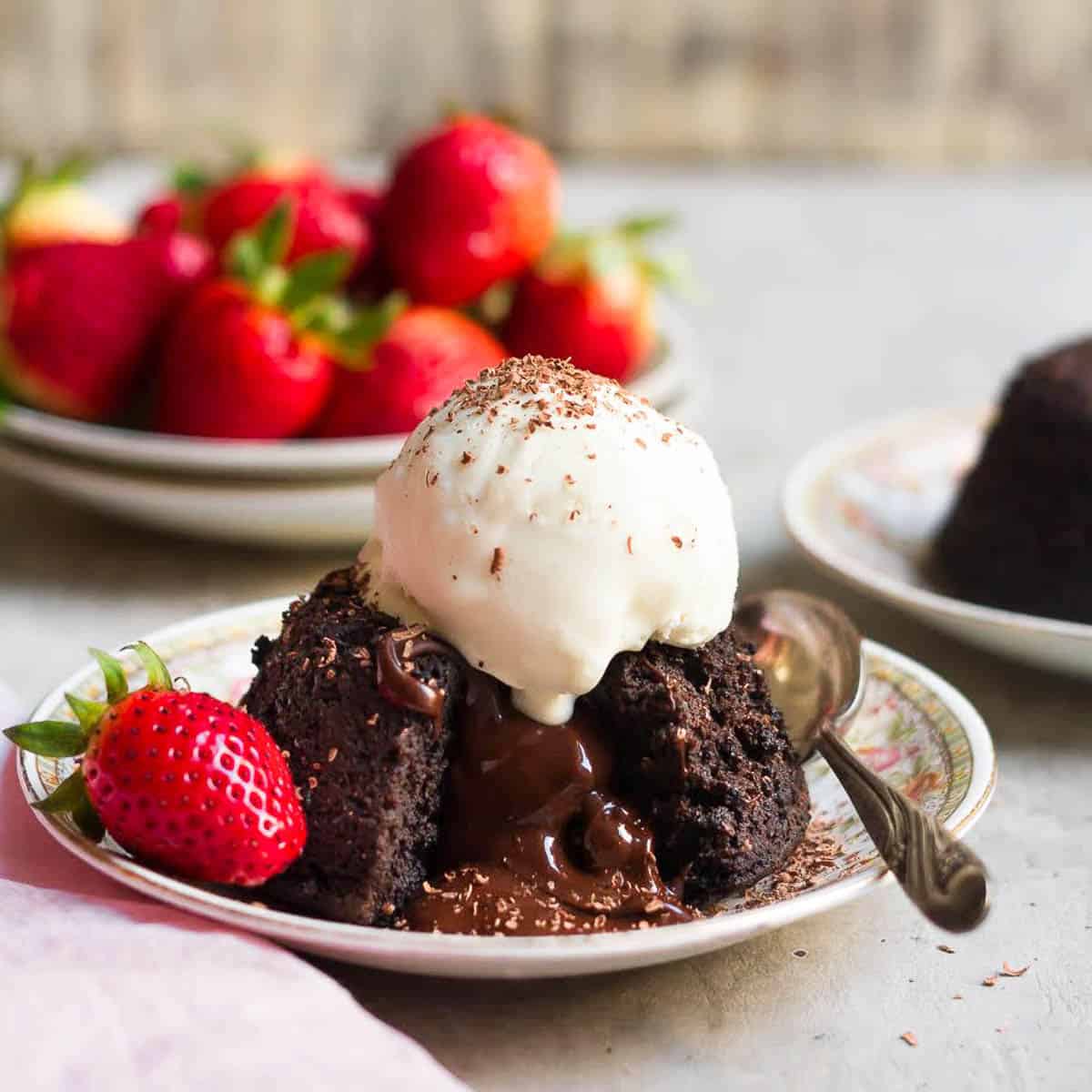 Lava cake with ice cream on top with a bite taken to show the melty interior.