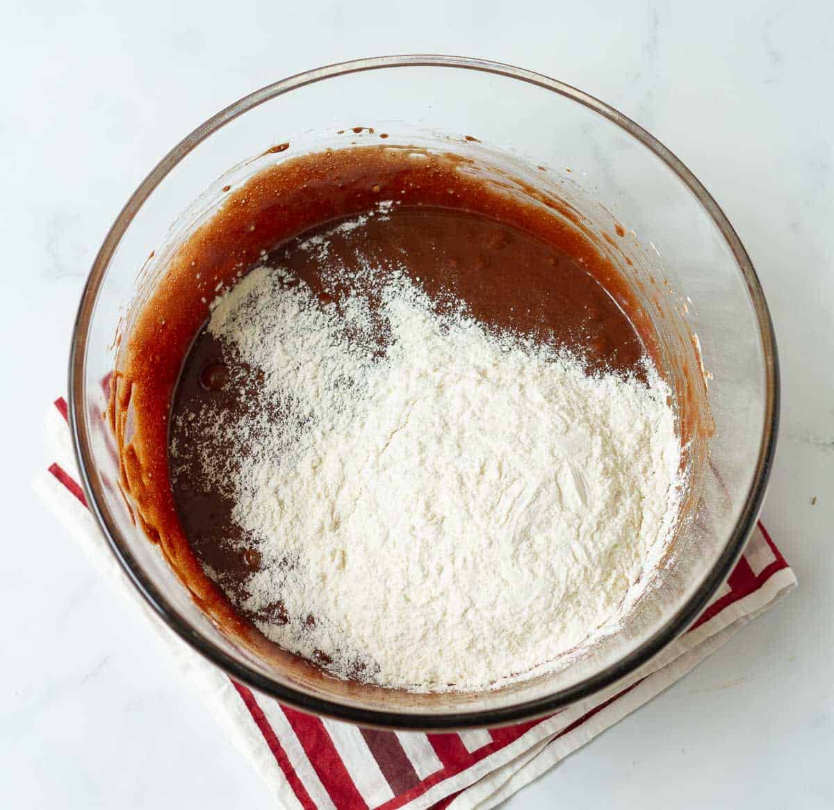 Flour on top of chocolate mixture in a bowl.