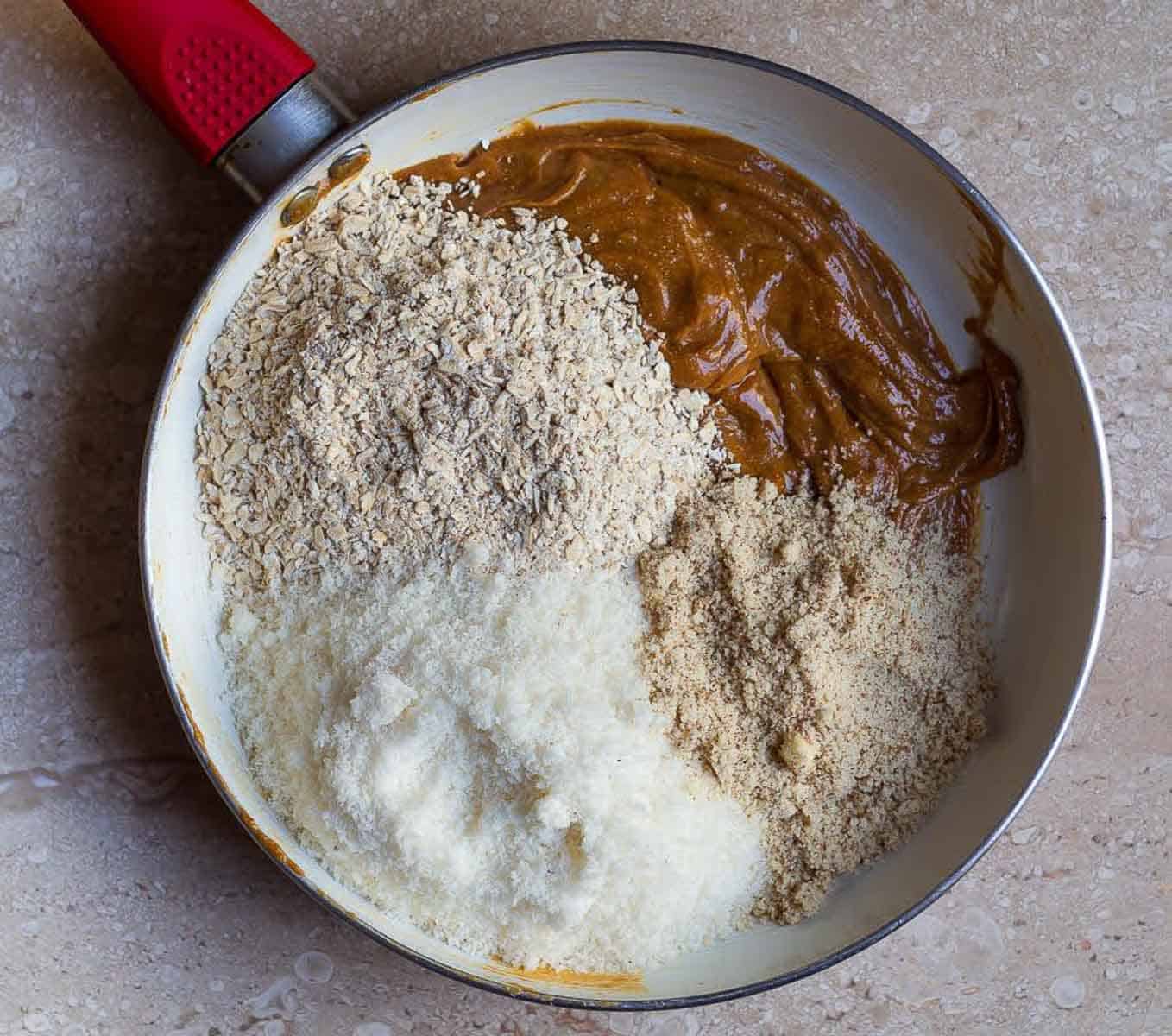 peanut butter, oats, desiccated coconut, and almond flour in a saucepan.