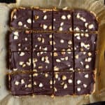 Chocolate peanut butter oatmeal bars cut into 16 squares on parchment paper.