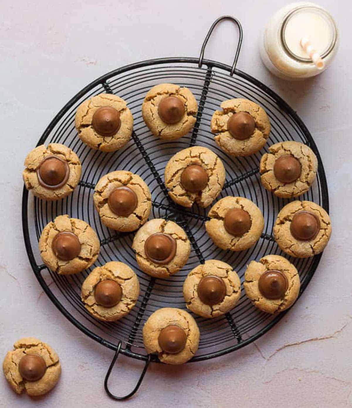 cookies on a metal trivet with a bottle of milk with a straw on the side.