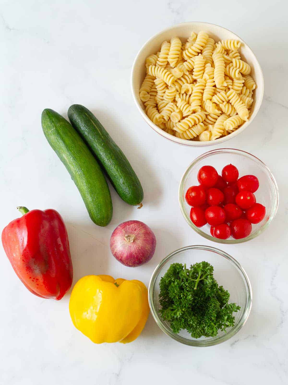 Vegetables and cooked pasta for making summer pasta salad.