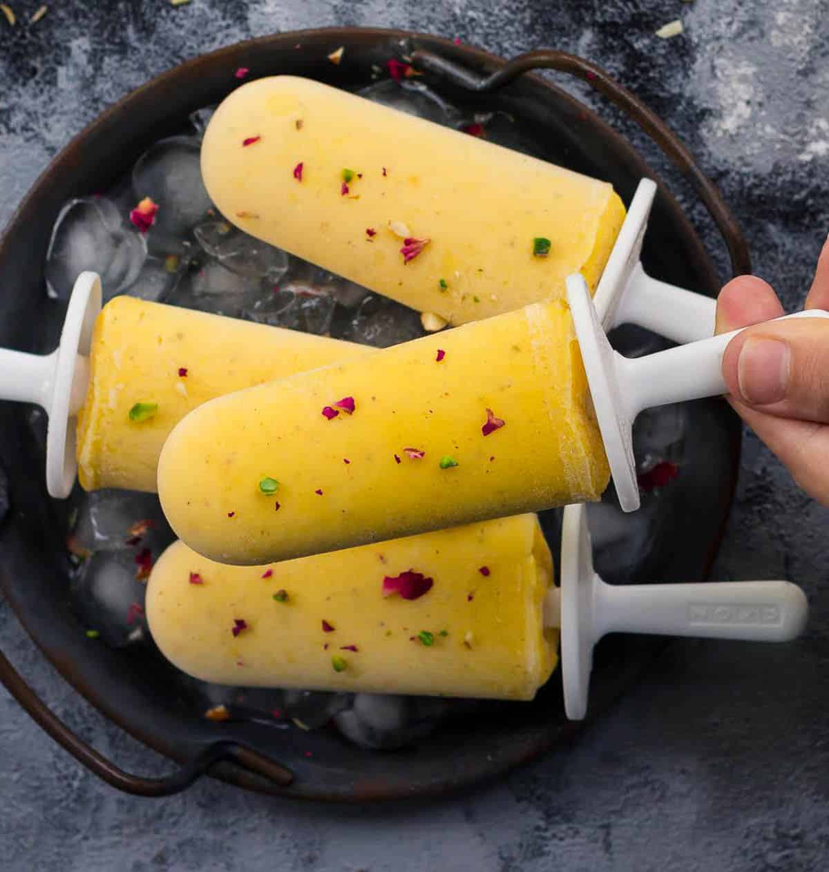 3 popsicles on a tray and 1 popsicle held on top.