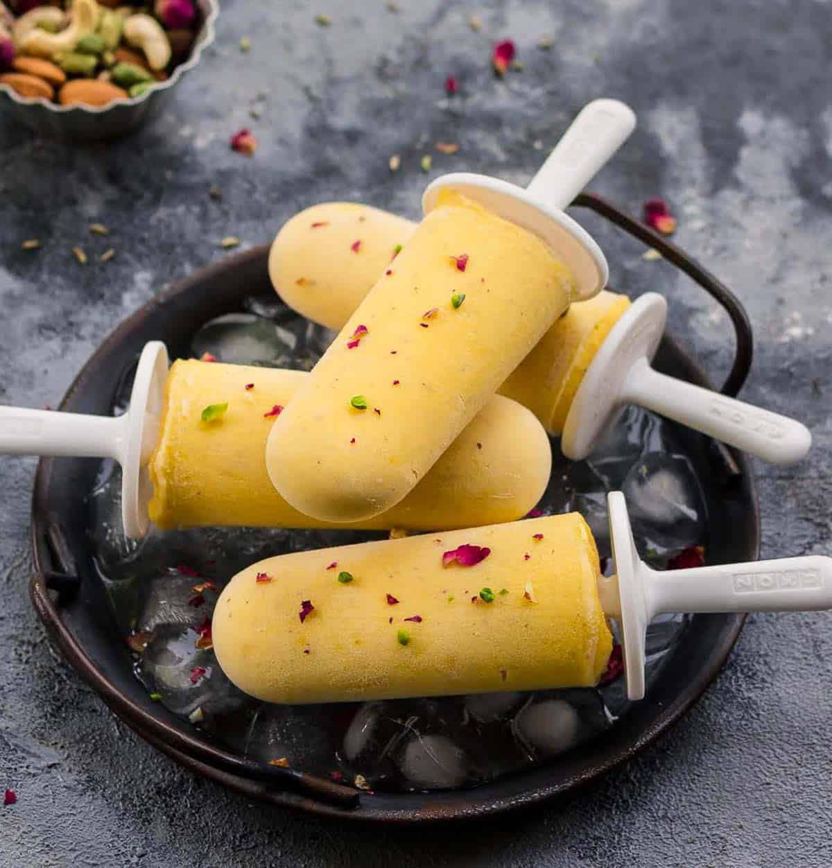 4 mango popsicles on a tray.
