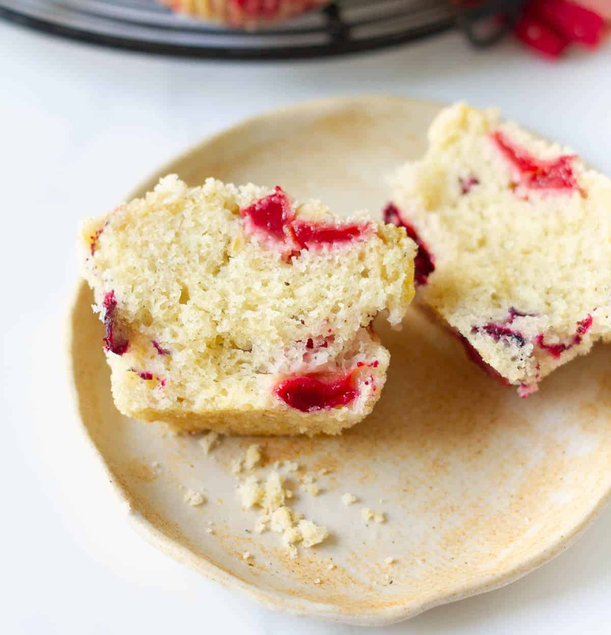 A muffin cut into half on a small plate.