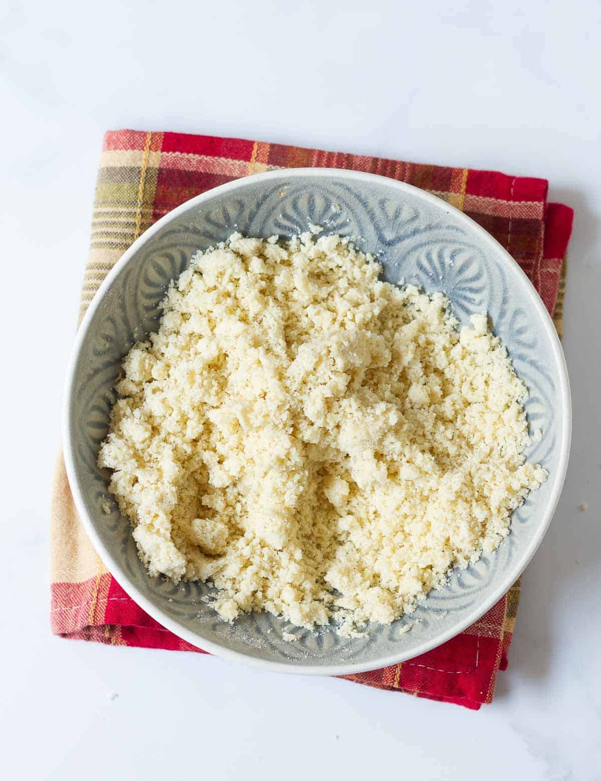 A mixture of flour, sugar, and melted butter in a bowl.