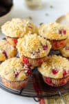 A stack of plum muffins on a wire rack.