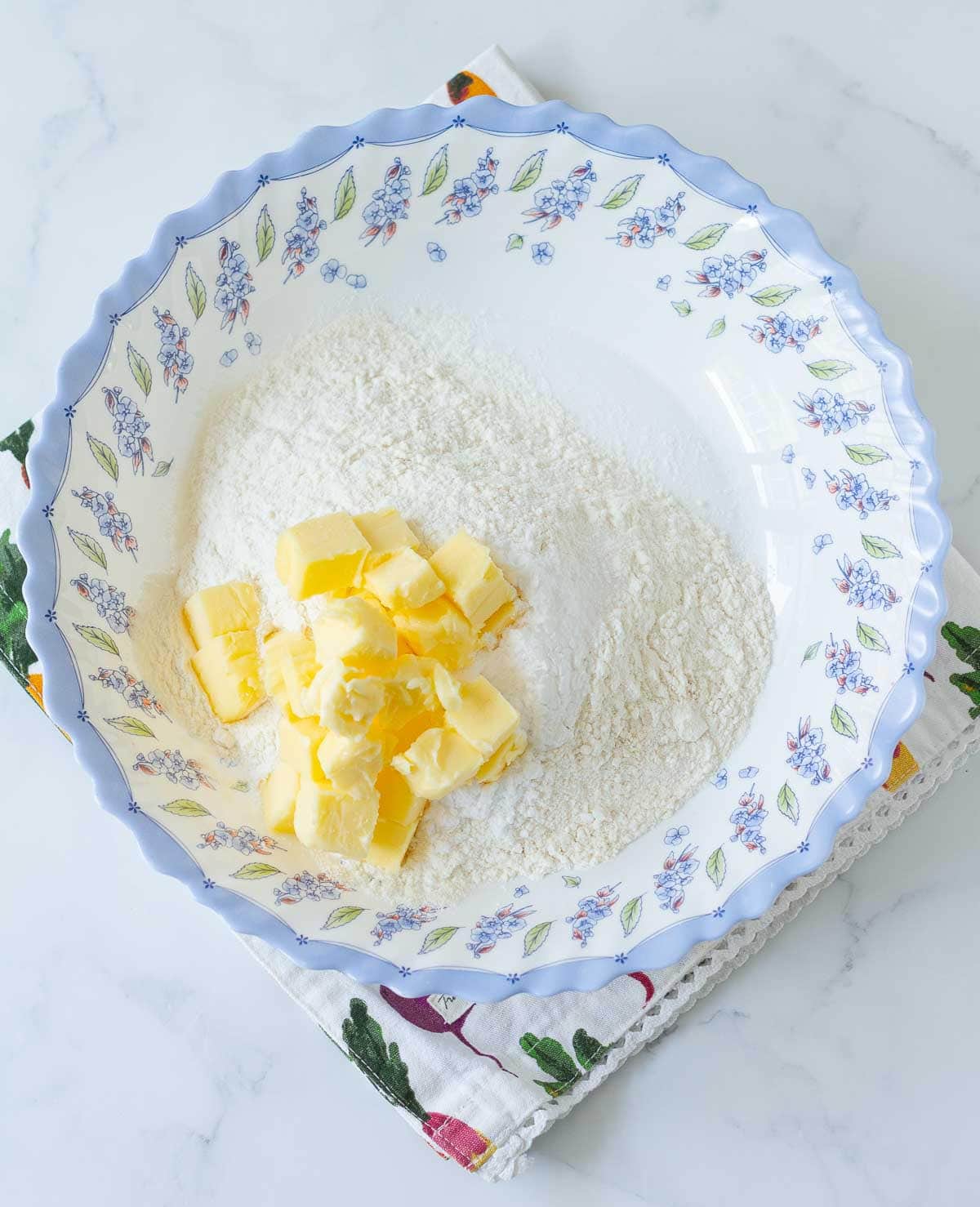 A bowl with flour, butter, sugar, and salt.
