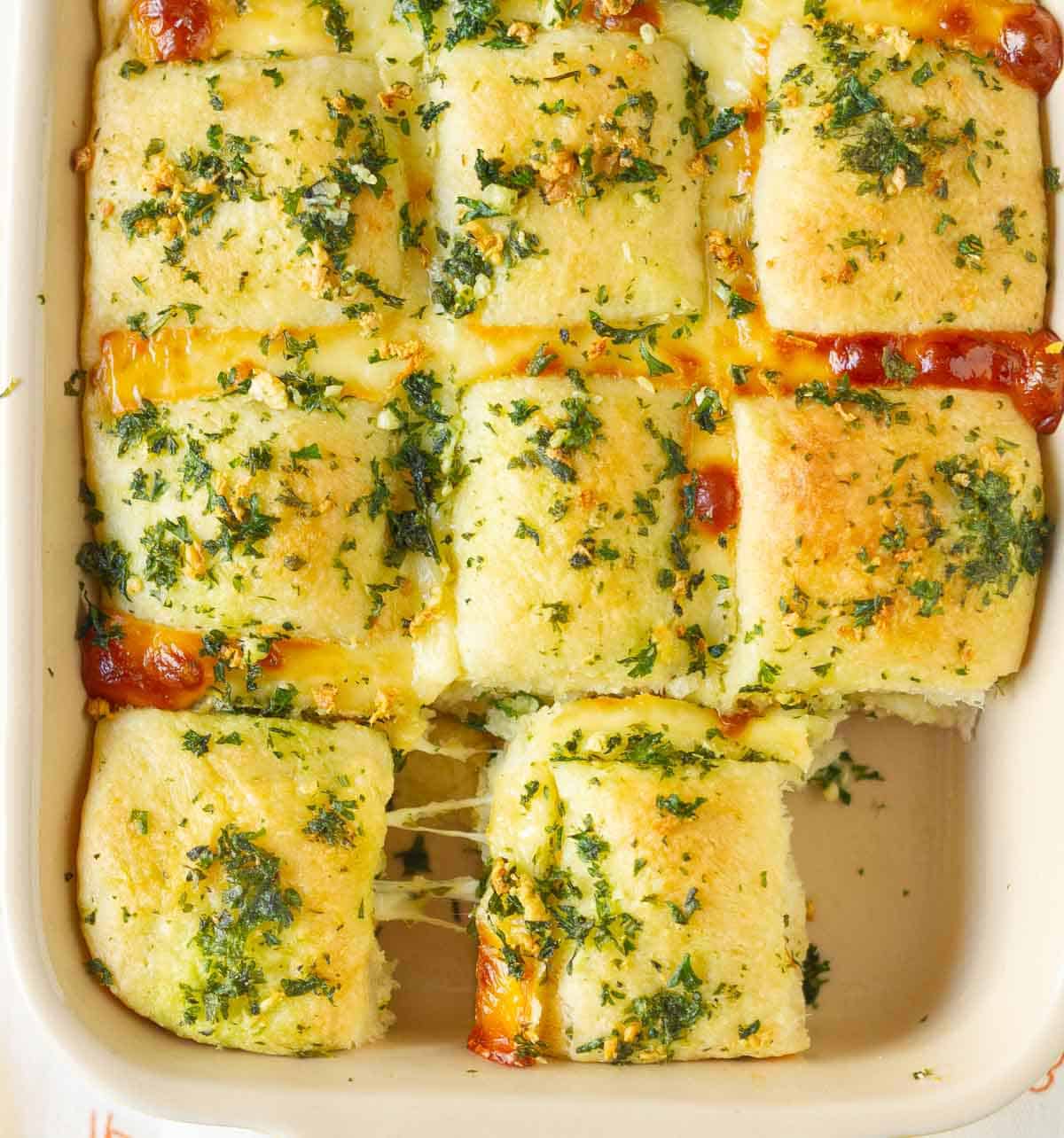 Garlic bread with melty cheese in a pan.