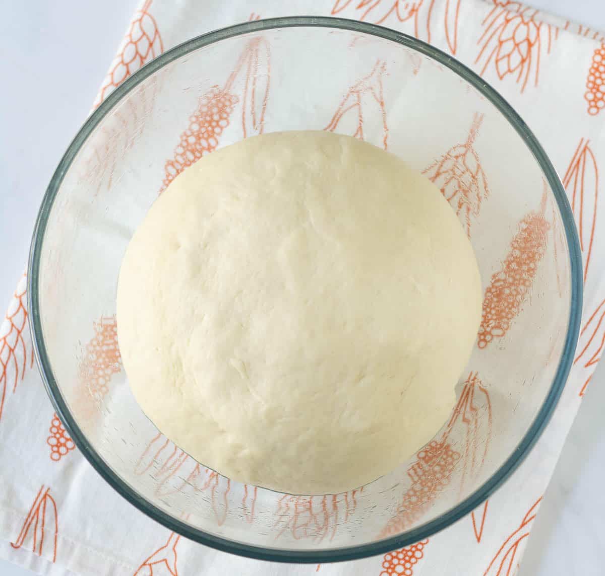 proofed bread dough in a glass bowl.