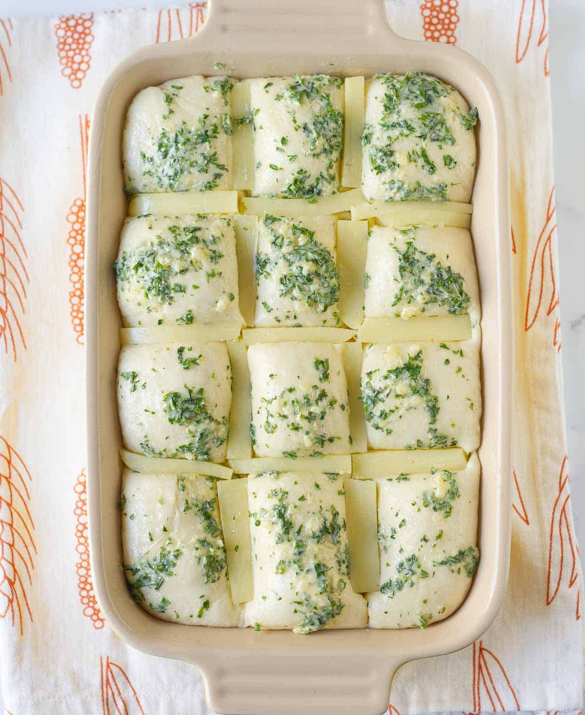 Bread dough brushed with garlic herb butter and stuffed with cheese pieces.