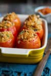 Baked stuffed tomatoes in a baking dish.