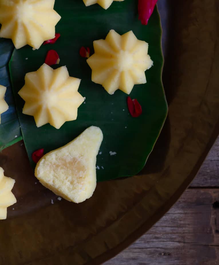 A cut half of a modak to show the filling on a platter.