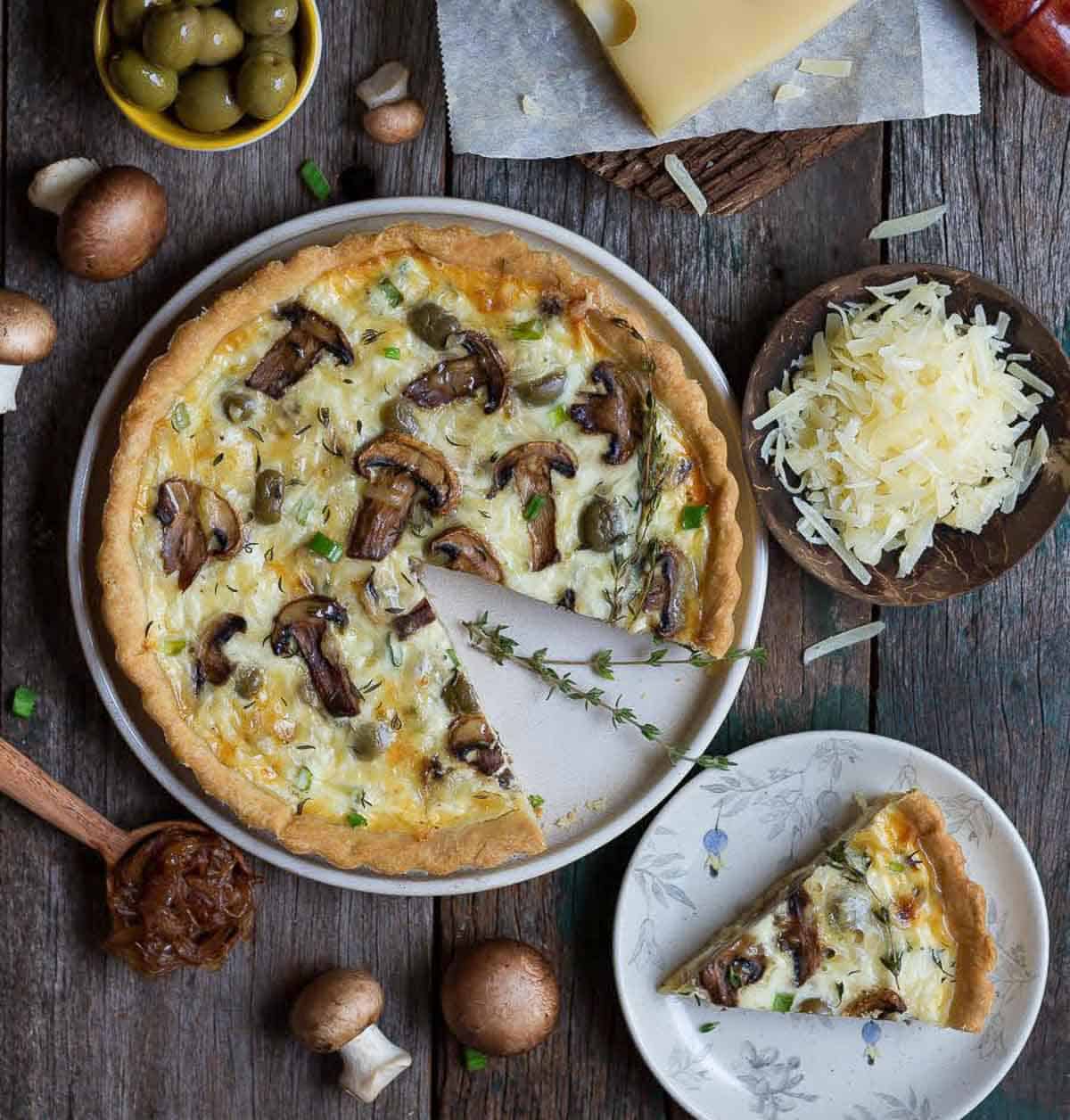 mushroom quiche with a slice on a small plate.