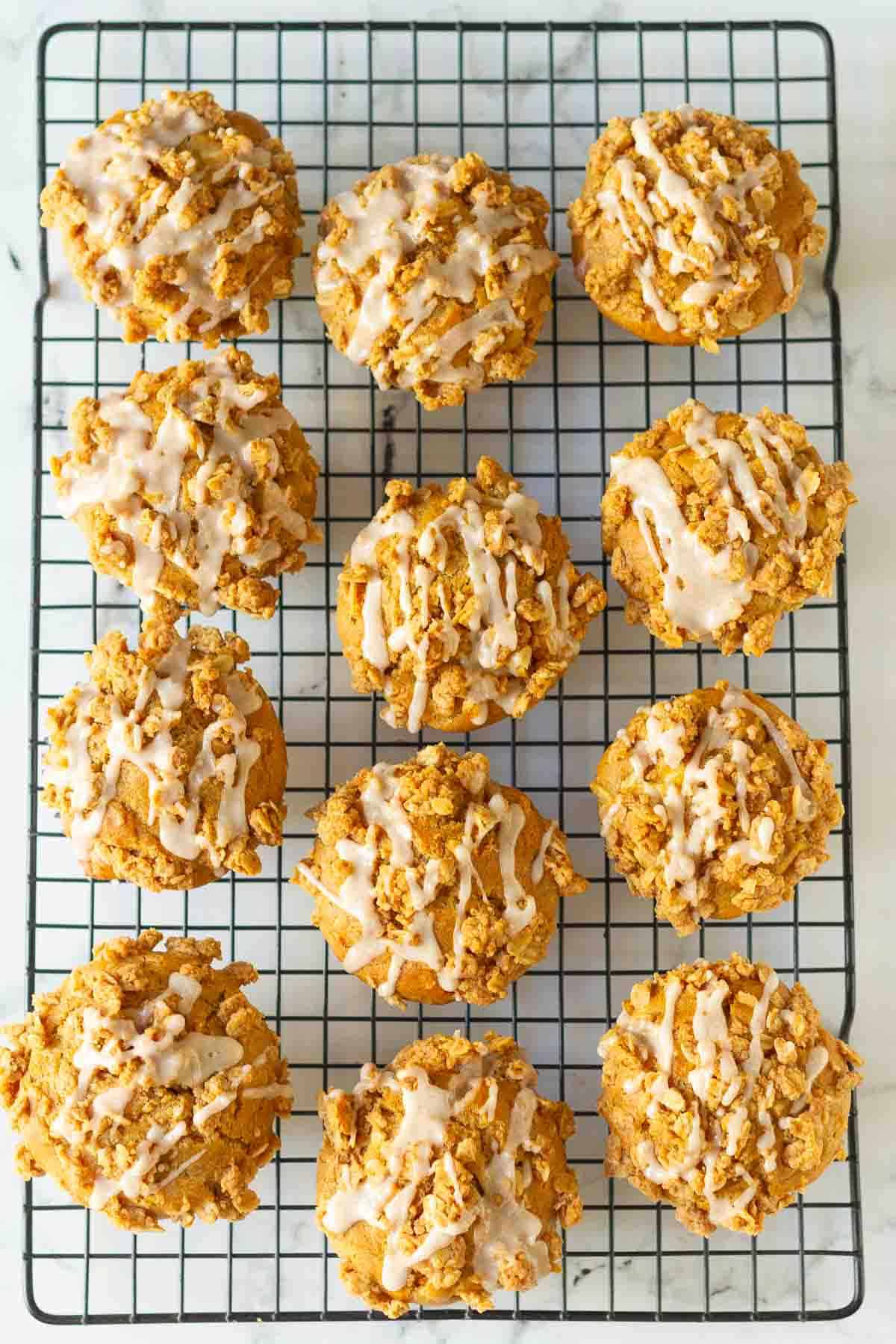 Peanut butter apple muffins with cinnamon drizzle on a wire rack.