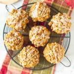 7 Peanut butter apple muffins with cinnamon glaze on a round wire rack.