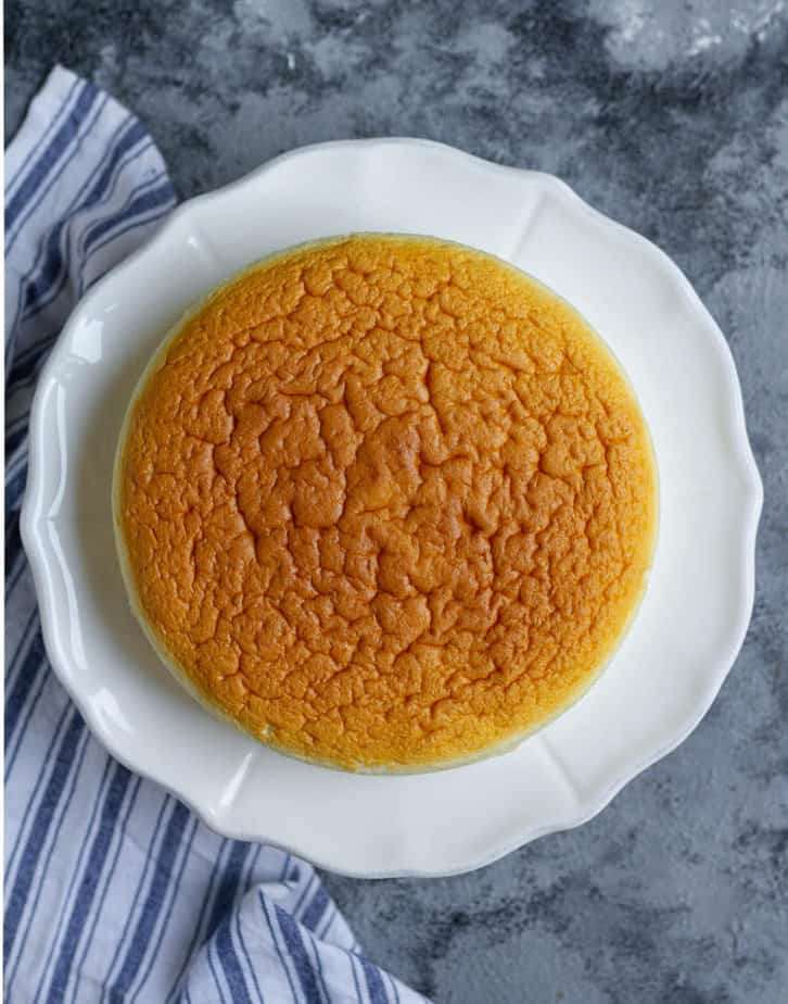 Baked cheesecake on a white platter.