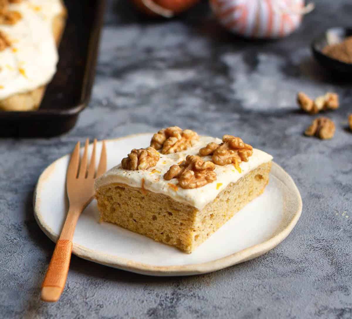 A slice of cake on a small plate with a fork.