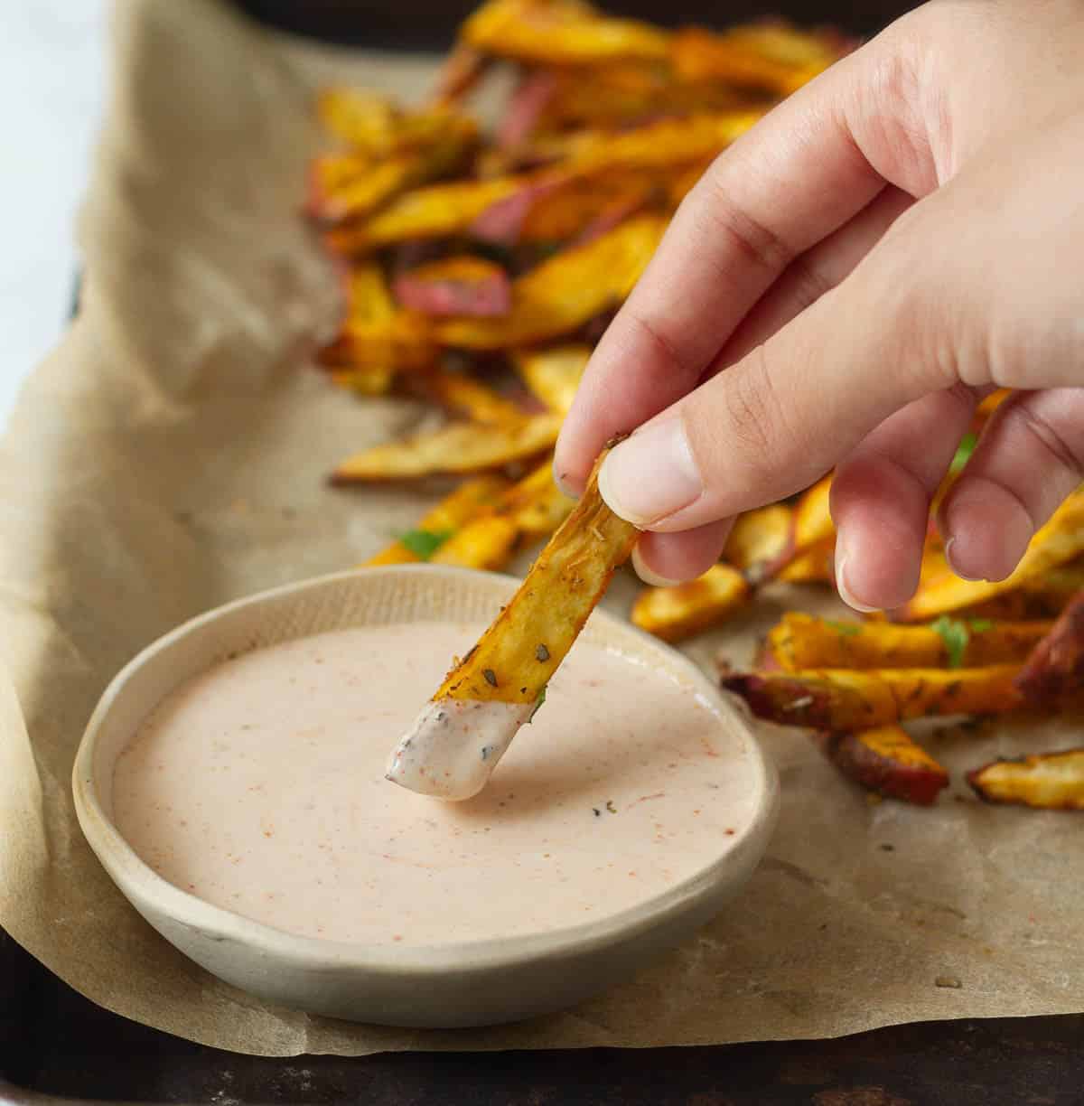 A sweet potato fry dipped in a sauce.