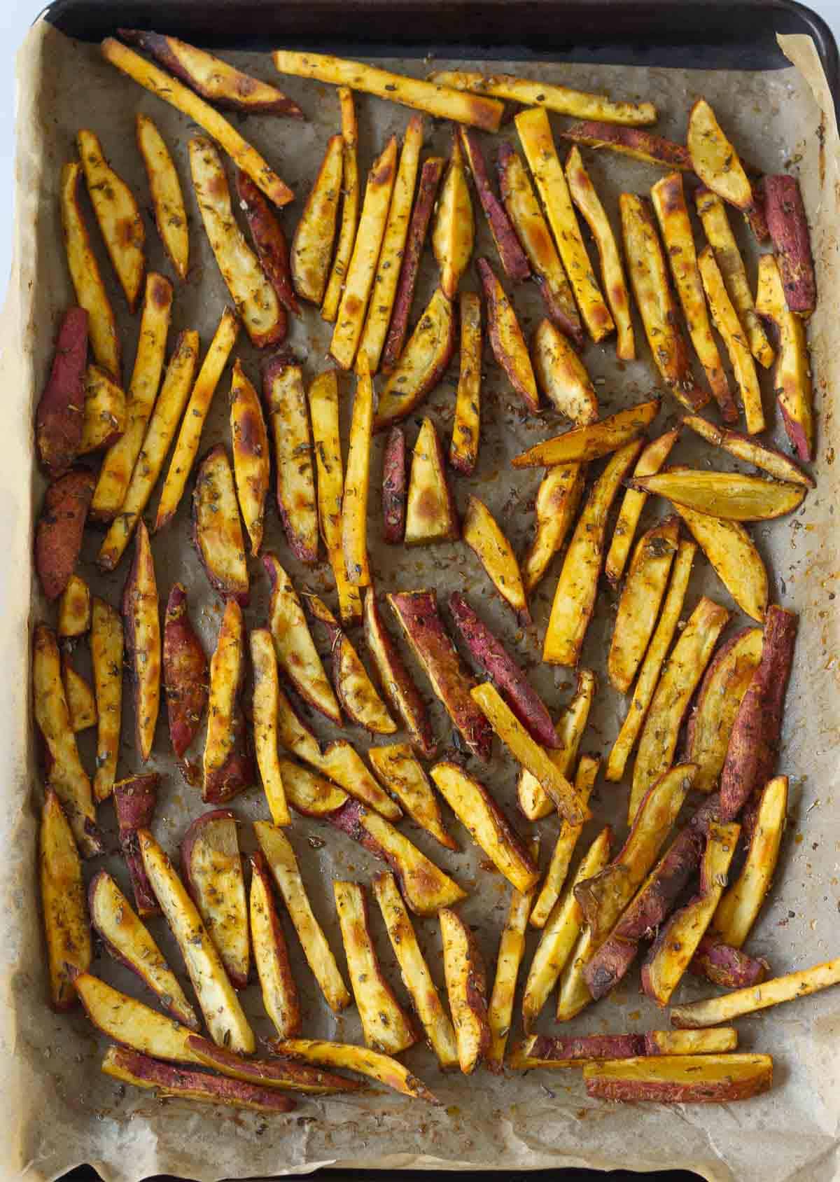 Baked sweet potato fries on parchment paper.