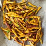 Baked sweet potato slices on parchment paper.