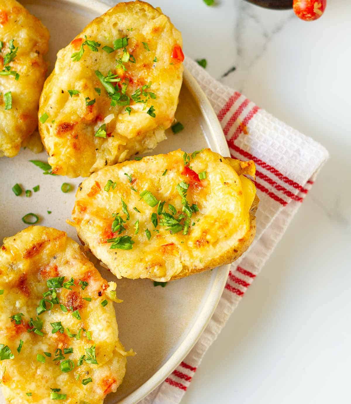 Cheesy baked potatoes on a plate.