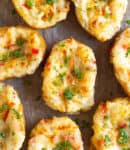 Baked potatoes topped with parsely and green onions.