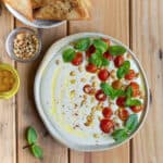 Feta dip with cherry tomatoes, pinenuts, olive oil and mint on top.