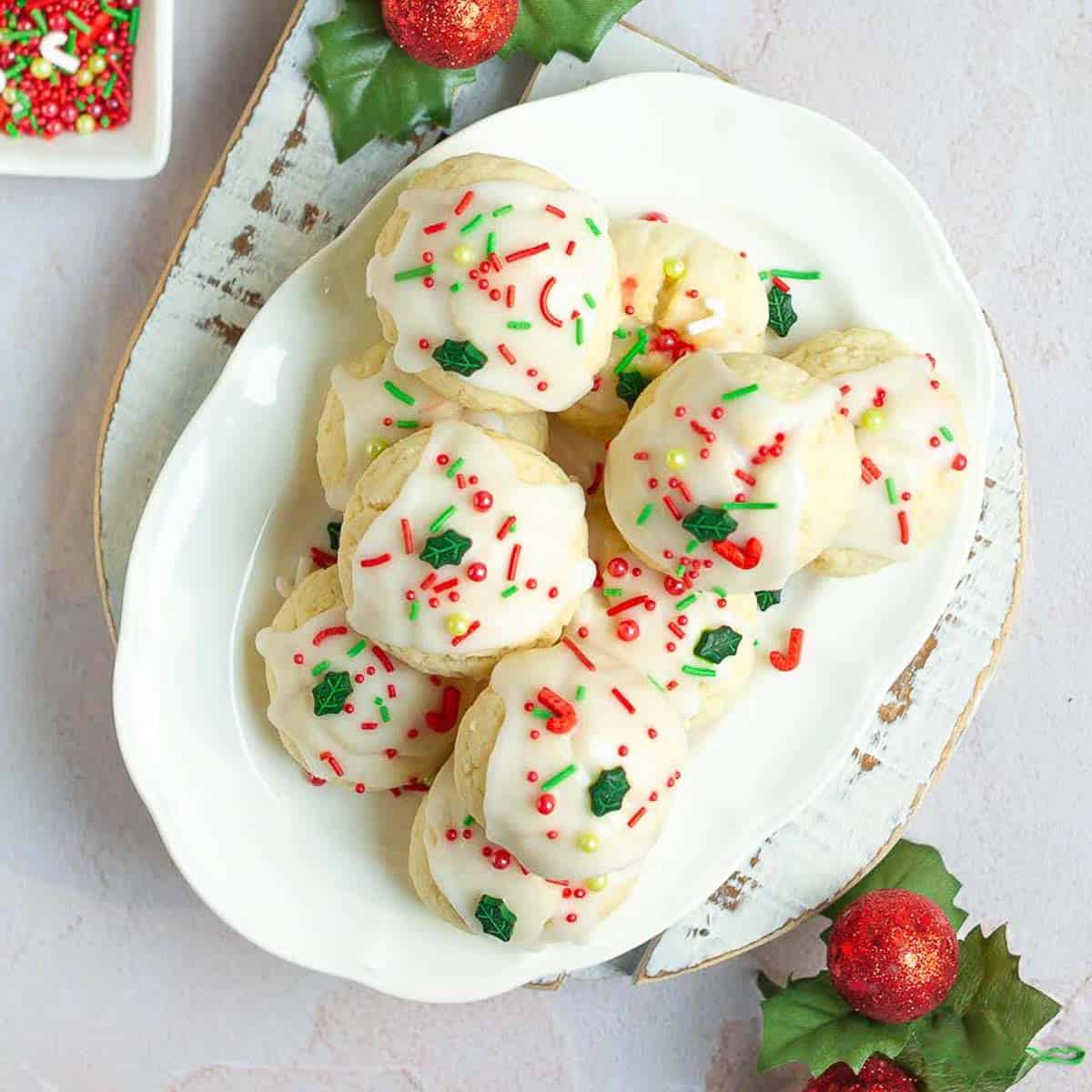 almond ricotta cookies with sprinkles on top on a white platter.