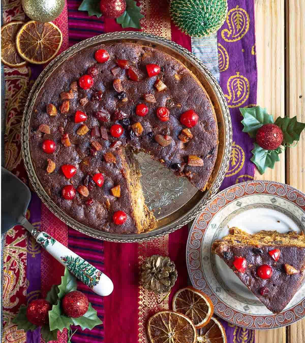 christmas rum cake with a slice taken out on a small plate.