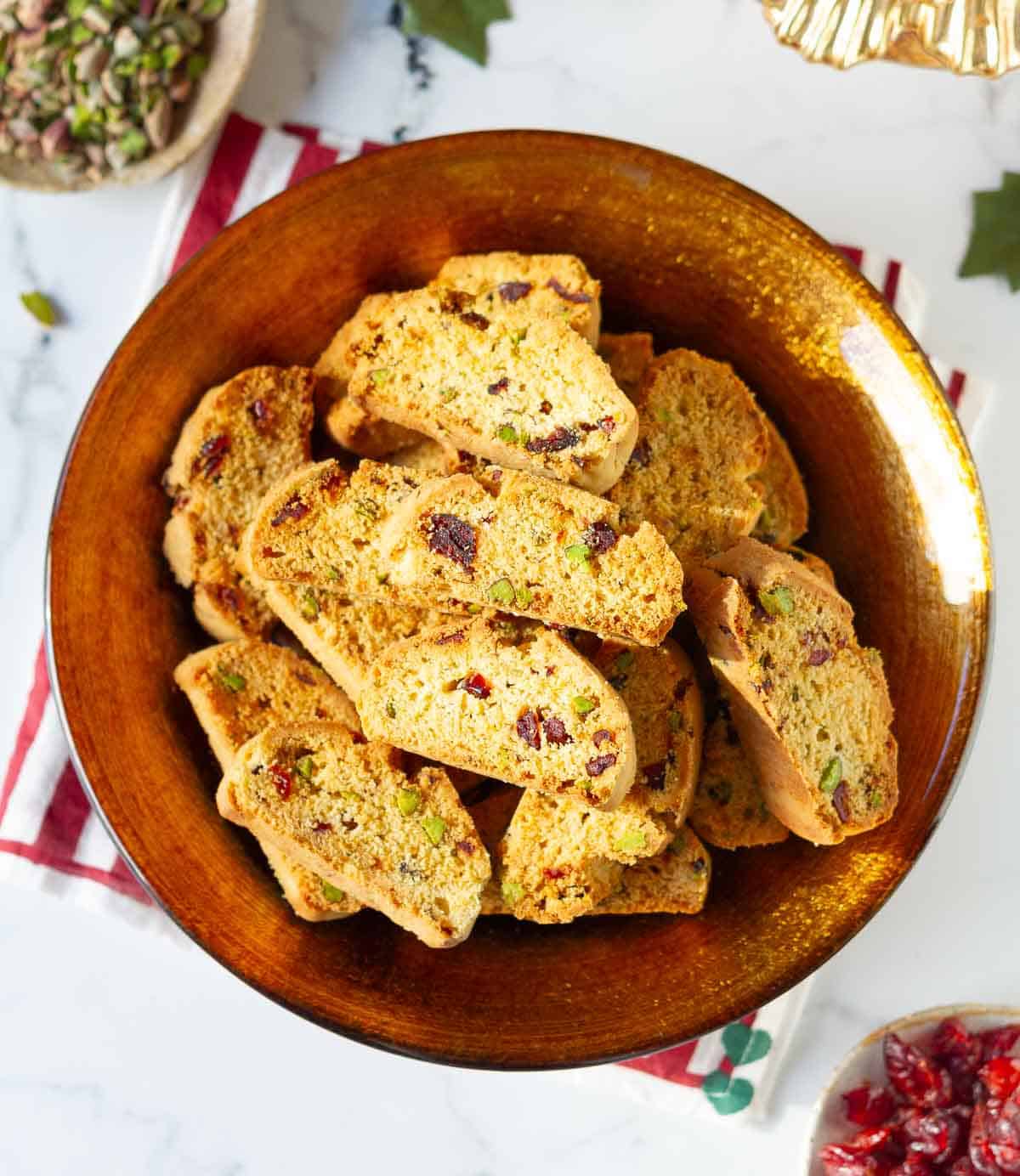 cranberry pistachio biscotti in a golden serving bowl.