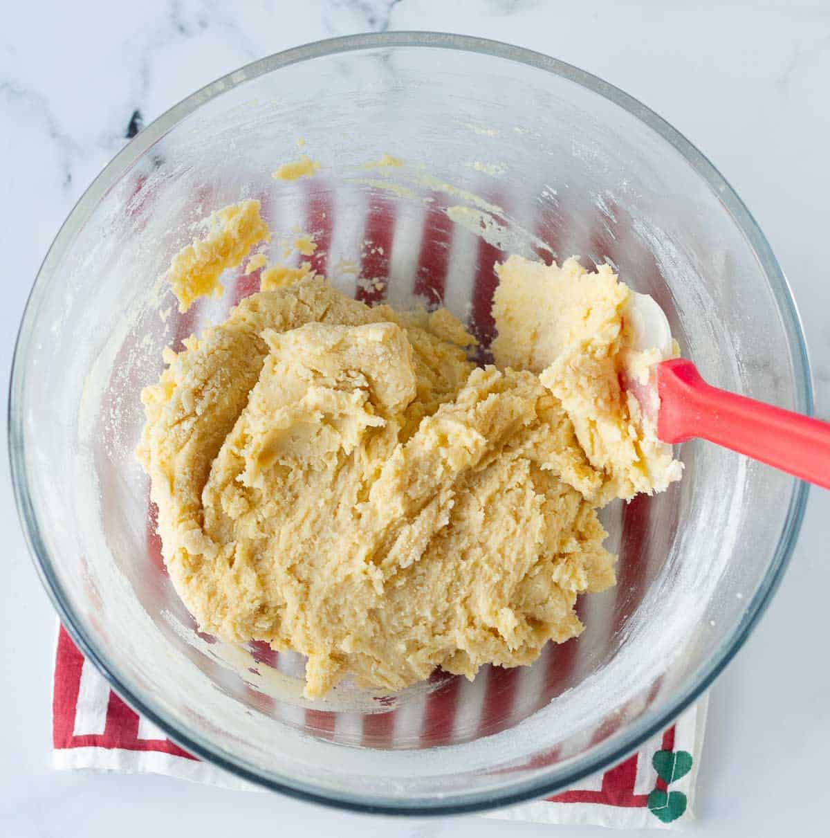 dough for biscotti in a mixing bowl with a spatula.