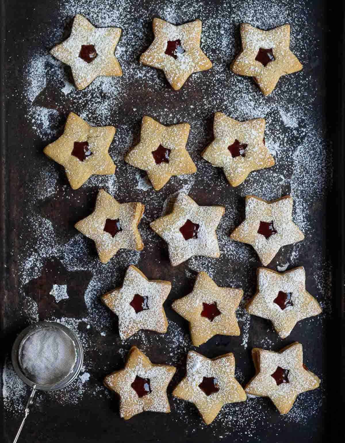 star-shaped linzer cookies with icing sugar sprinkled on top.