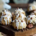 Maple pecan cookies with glaze on a wooden board.